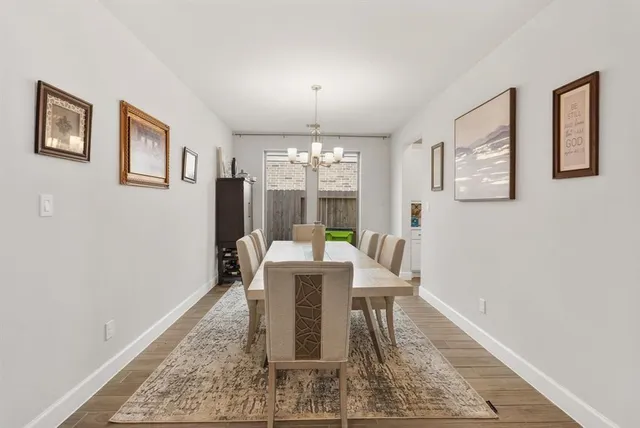 a dining room with wooden floor and white walls