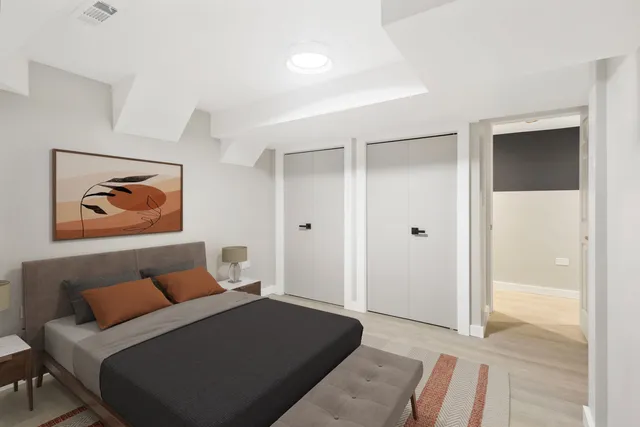 a bedroom with a bed and painting on the wall