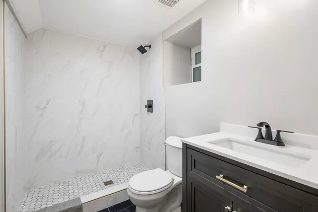 a bathroom with a sink a toilet and shower