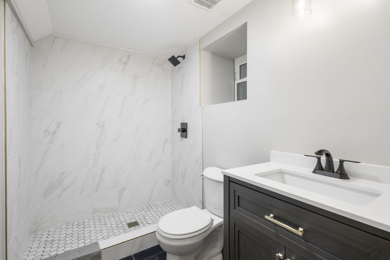 6129 North Ravenswood Avenue, Unit 1 Chicago, IL 60660 - Photo 30 of 33 a bathroom with a sink a toilet and shower