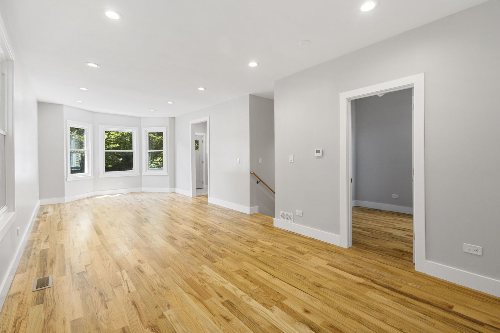 6129 North Ravenswood Avenue, Unit 1 Chicago, IL 60660 - Photo 8 of 33 a view of an empty room with wooden floor and a window