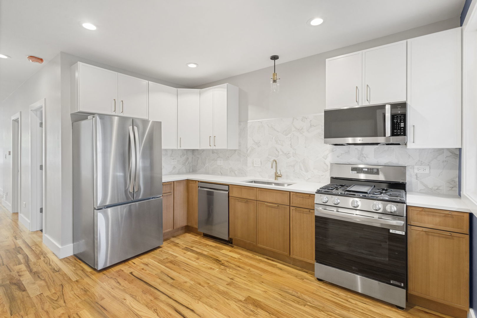 6129 North Ravenswood Avenue, Unit 1 Chicago, IL 60660 - Photo 9 of 33 a kitchen with stainless steel appliances granite countertop a stove a refrigerator and a microwave