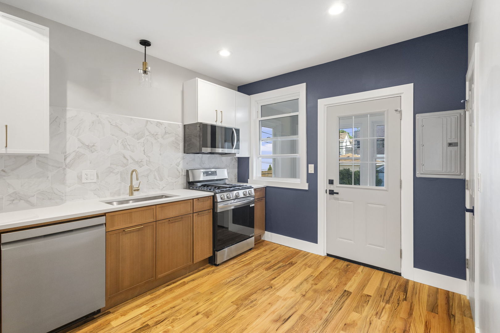 6129 North Ravenswood Avenue, Unit 1 Chicago, IL 60660 - Photo 10 of 33 a kitchen with stainless steel appliances granite countertop a refrigerator a sink dishwasher a stove with wooden cabinets and floor