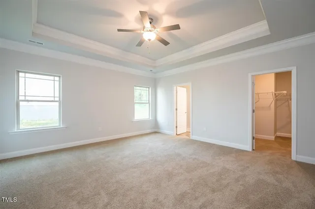 a view of an empty room and chandelier fan