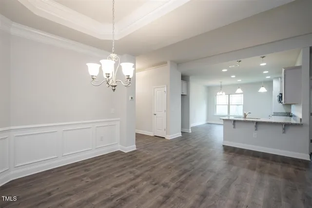 a view of a kitchen with a sink and dishwasher with wooden floor