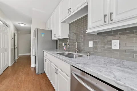a kitchen with granite countertop a sink and refrigerator