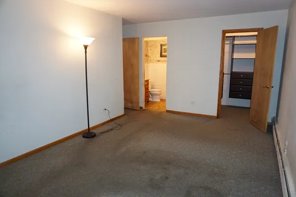 an empty room with closet and mirror