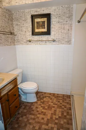 a bathroom with a toilet sink and mirror