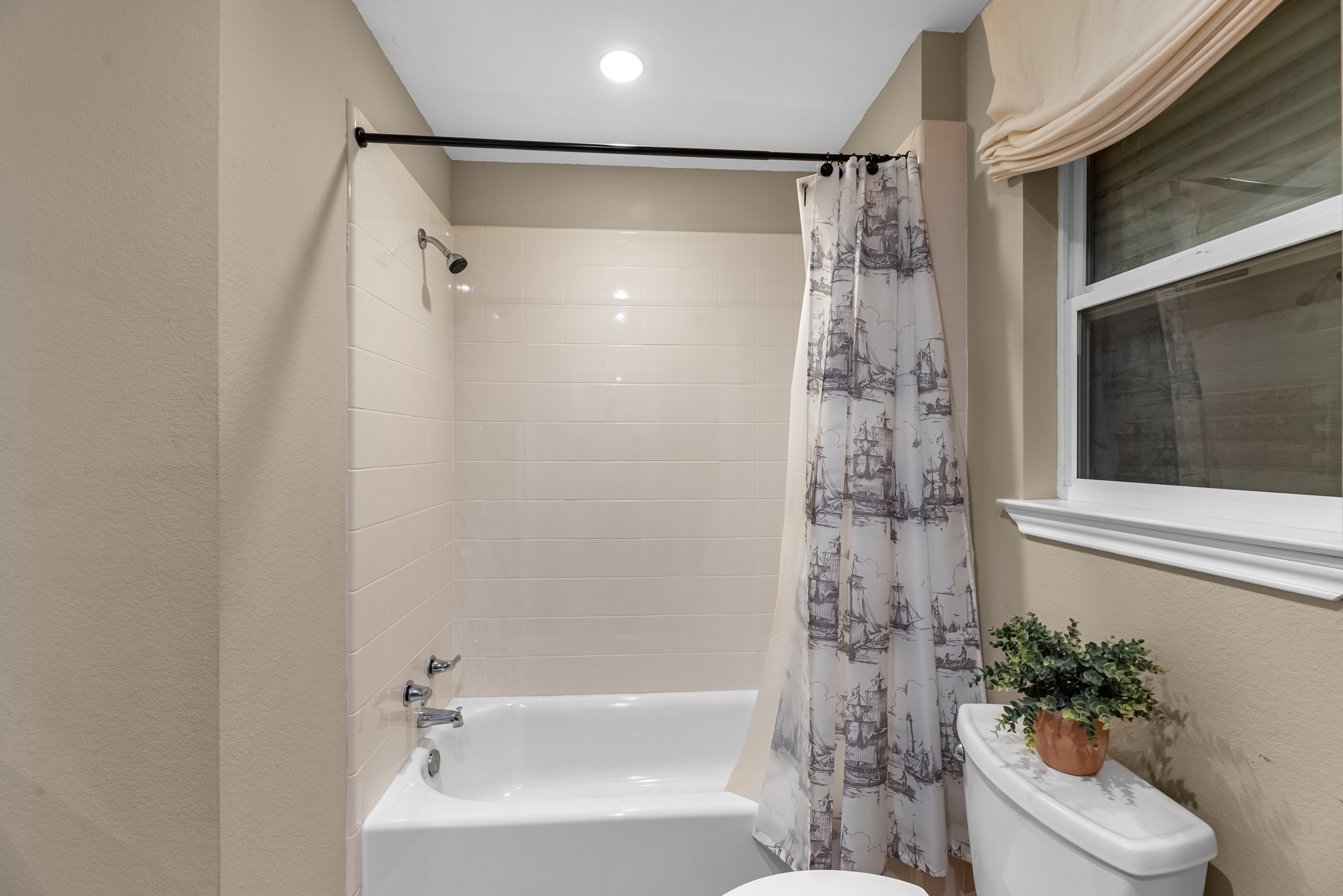 211 Captains Road Anahuac, TX 77514 - Photo 31 of 39 a bathroom with a shower curtain a window and a sink