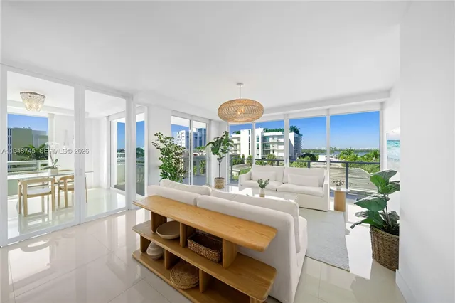 a room with stainless steel appliances kitchen island granite countertop a large window and a white table