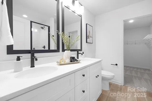 a bathroom with double vanity and a mirror