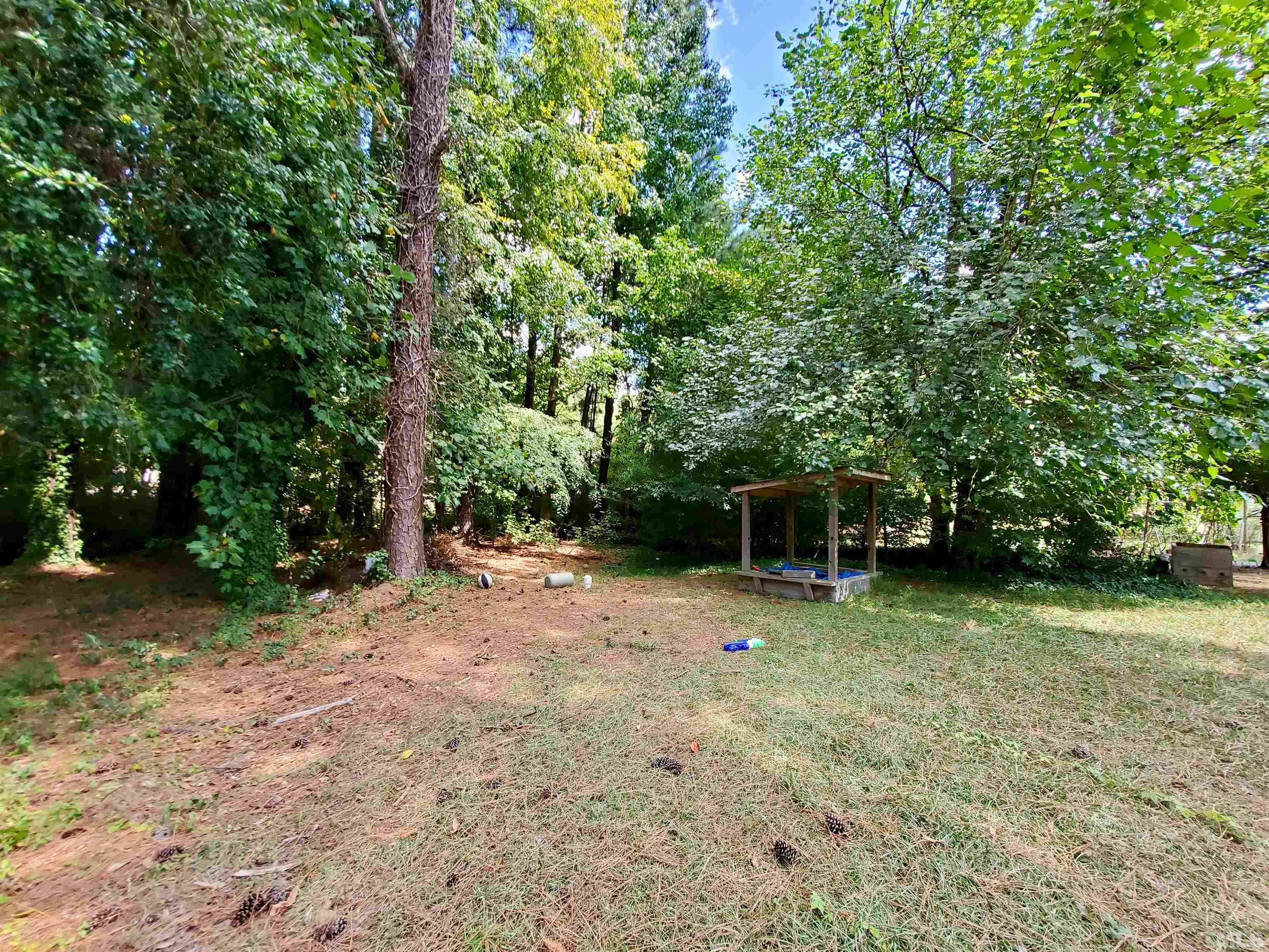 3505 Neptune Drive Raleigh, NC 27604 - Photo 6 of 28 a backyard of a house with plants and large trees