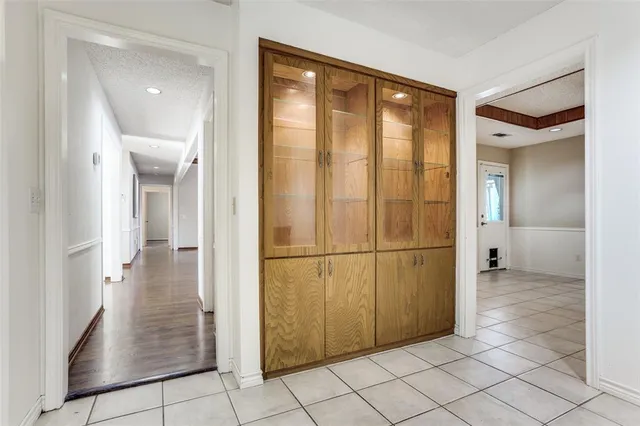 a view of a hallway with wooden cabinets