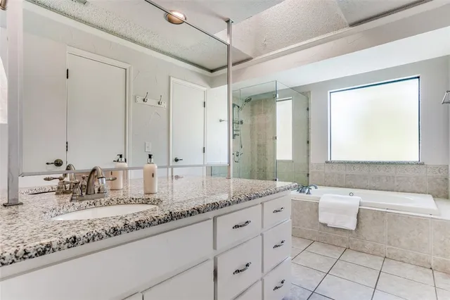a bathroom with a tub sink shower and mirror