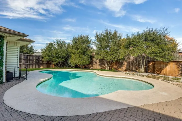 a view of house with swimming pool and yard