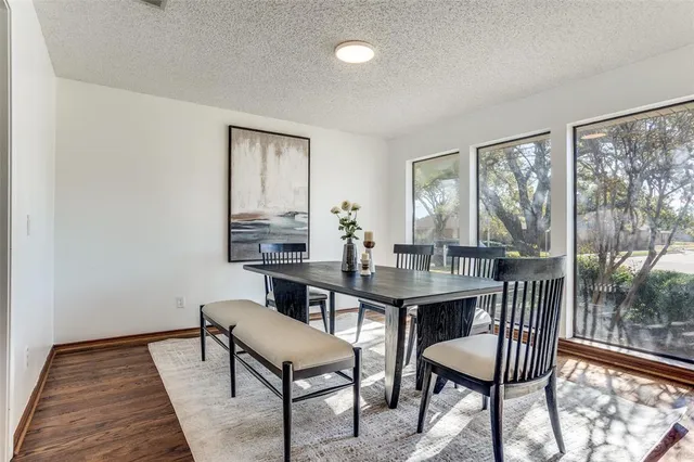 a view of a dining room with furniture wooden floor and a floor to ceiling window