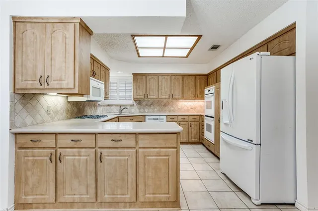 a kitchen with white cabinets and white appliances