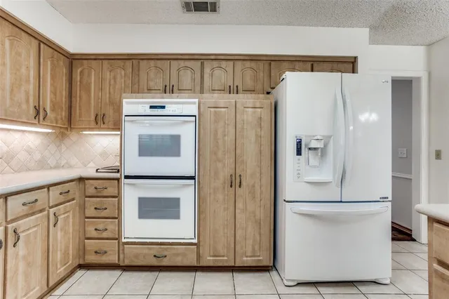 a kitchen with cabinets and a refrigerator