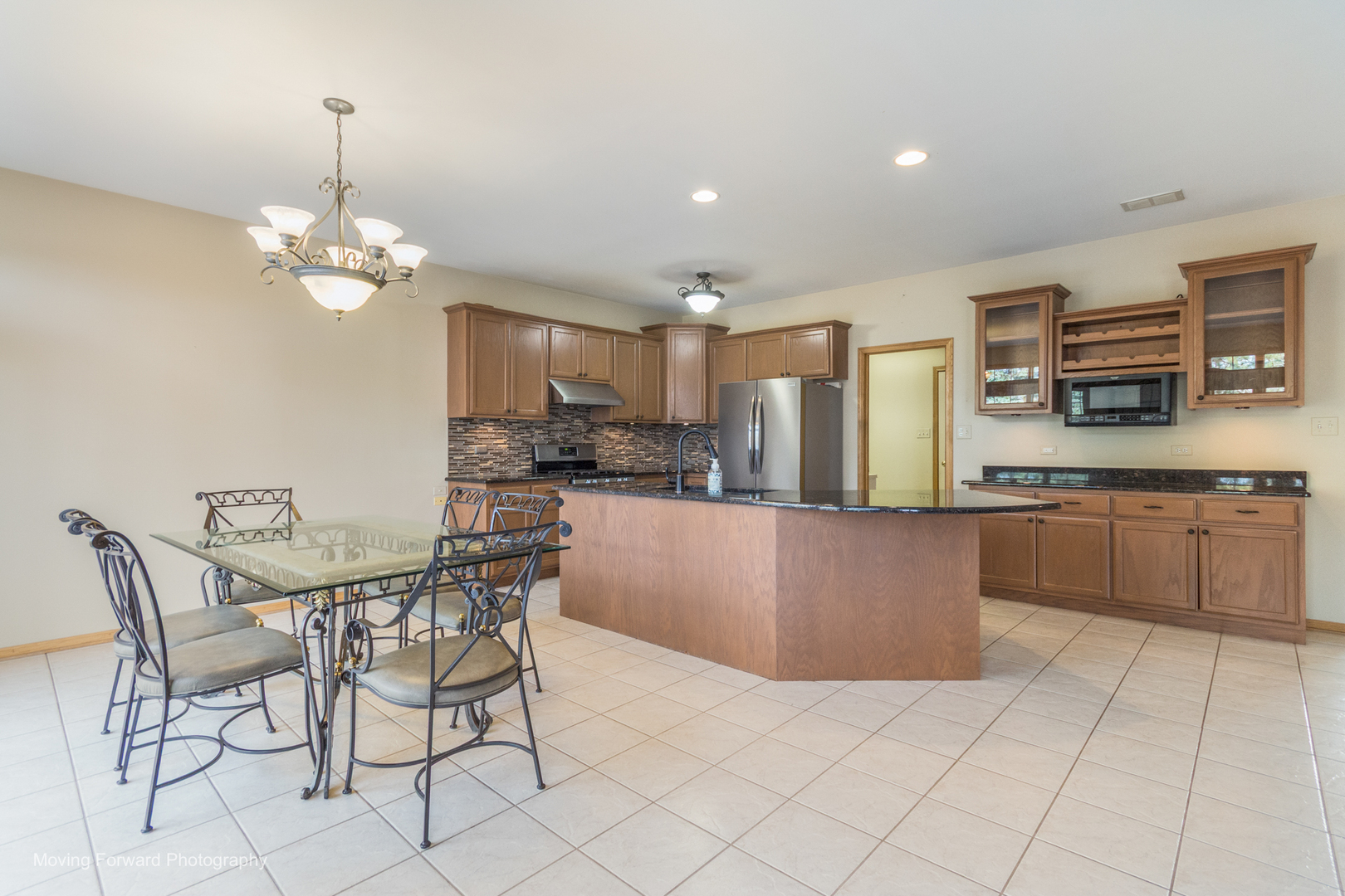 14825 Steven Court Lemont, IL 60439 - Photo 20 of 50 a kitchen with stainless steel appliances granite countertop a stove top oven a refrigerator a kitchen island and chairs