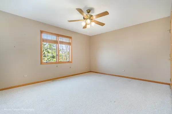 an empty room with a window and a ceiling fan