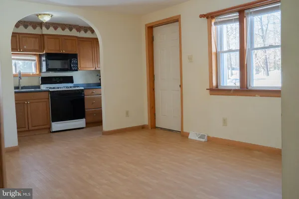 a view of an empty room with a fireplace and a window