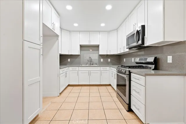 a kitchen with stainless steel appliances granite countertop a stove a sink and a refrigerator