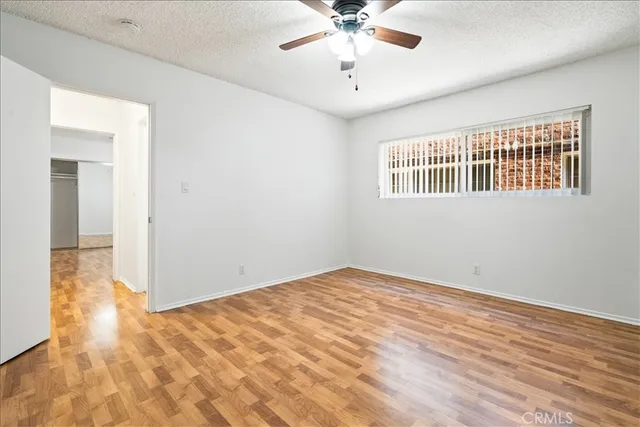 a view of an empty room with a chandelier fan