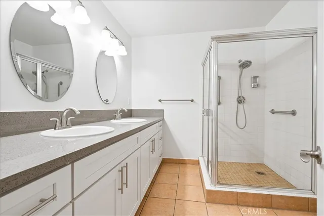 a bathroom with a granite countertop sink mirror and a shower