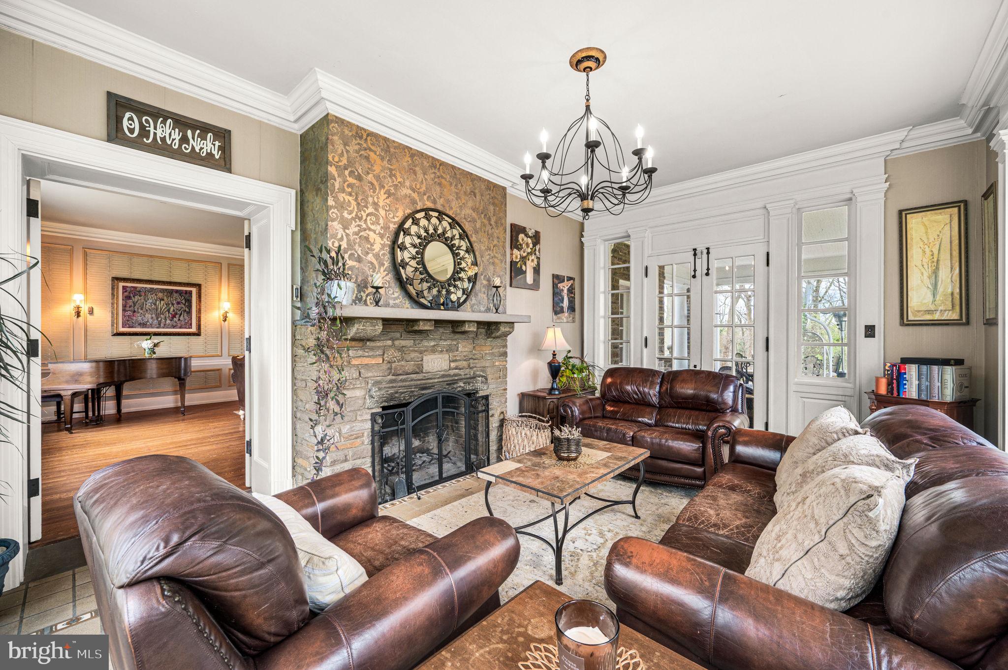 1018 Beech Road Wallingford, PA 19086 - Photo 10 of 66 a living room with furniture a fireplace and a chandelier