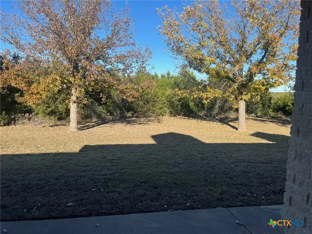 a kitchen with kitchen island granite countertop stainless steel appliances cabinets a sink and a wooden floor