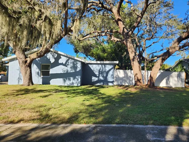 a backyard of a house with table and chairs