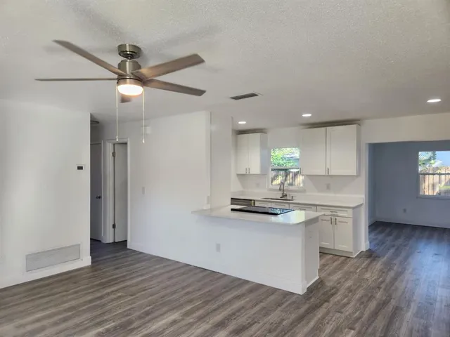 a kitchen with kitchen island white cabinets and stainless steel appliances