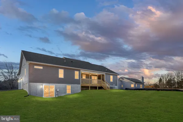 a kitchen with stainless steel appliances kitchen island granite countertop a stove a sink a refrigerator a center island and a wooden floor