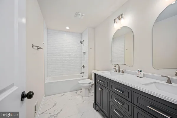 a spacious bathroom with a granite countertop sink a mirror and a shower