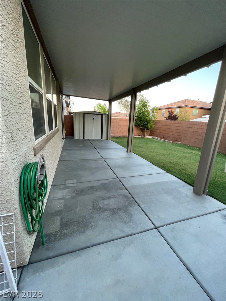 9325 Keystone Ridge Avenue Las Vegas, NV 89148 - Photo 16 of 17 A spacious covered patio extends to a manicured lawn, perfect for outdoor enjoyment.