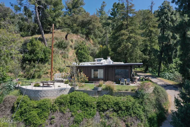 a view of the patio with couches and a table and chairs with wooden fence