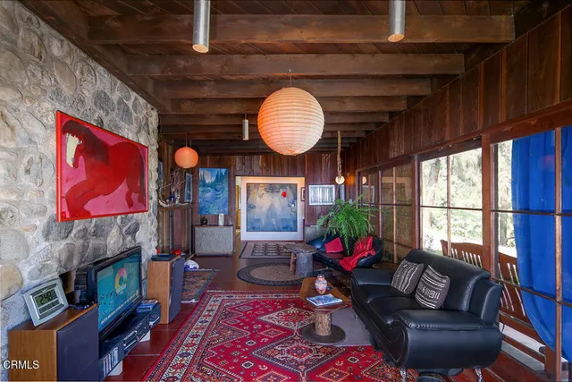 a living room with fireplace furniture and a large window