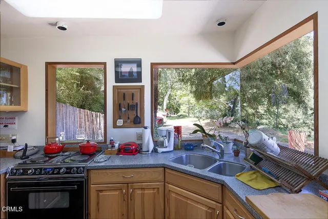 a kitchen with a stove a sink and a wooden cabinets