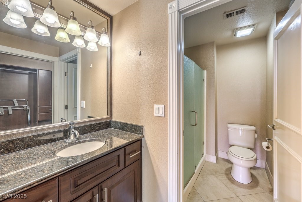 270 East Flamingo Road, Unit 115 Las Vegas, NV 89169 - Photo 18 of 29 Bathroom featuring a textured wall, light tile patterned floors, vanity, and a stall shower