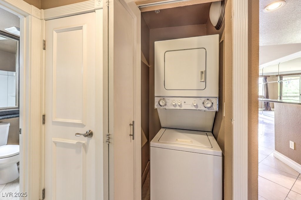 270 East Flamingo Road, Unit 115 Las Vegas, NV 89169 - Photo 23 of 29 Washroom with light tile patterned flooring, estacked washer and dryer, and a textured ceiling