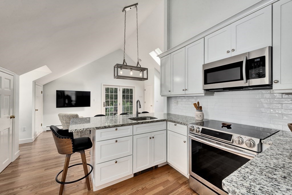 1 Tanglewood Road Boxford, MA 01921 - Photo 19 of 40 a kitchen with stainless steel appliances kitchen island granite countertop a stove and a wooden floor