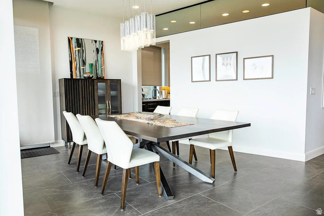1500 Split Rock, Unit 150 Ivins, UT 84738 - Photo 9 of 14 Modern dining area featuring a linear glass chandelier, recessed ceiling lights, and large format tile flooring