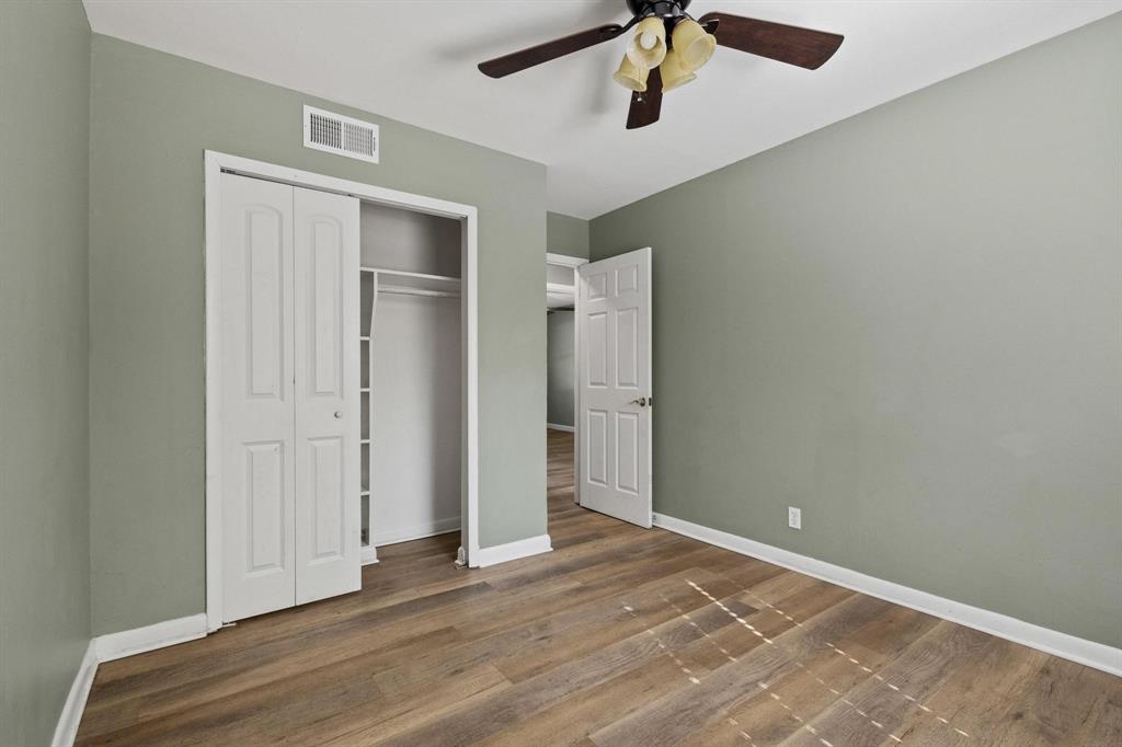 1704 West Birge Street Sherman, TX 75092 - Photo 12 of 23 an empty room with wooden floor ceiling fan and windows