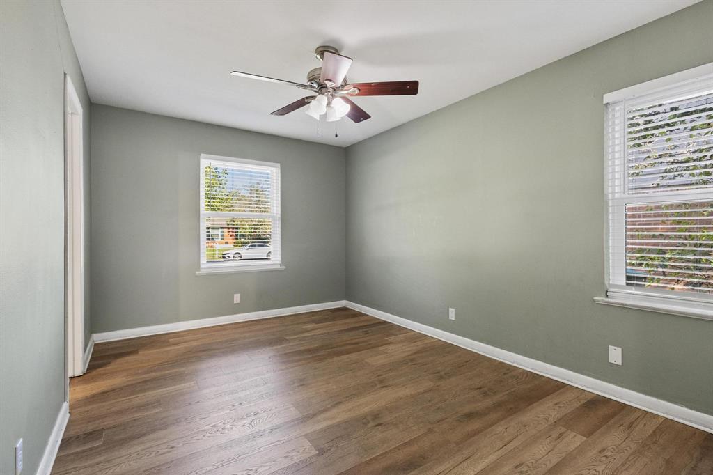 1704 West Birge Street Sherman, TX 75092 - Photo 16 of 23 an empty room with wooden floor chandelier fan and windows