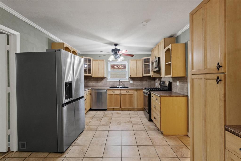 1704 West Birge Street Sherman, TX 75092 - Photo 5 of 23 a kitchen with a refrigerator a sink and dishwasher