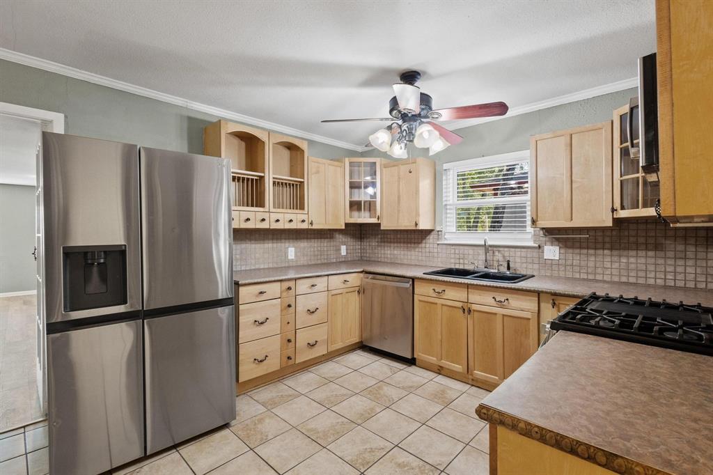 1704 West Birge Street Sherman, TX 75092 - Photo 6 of 23 a kitchen with stainless steel appliances granite countertop a refrigerator a sink dishwasher a stove and white cabinets