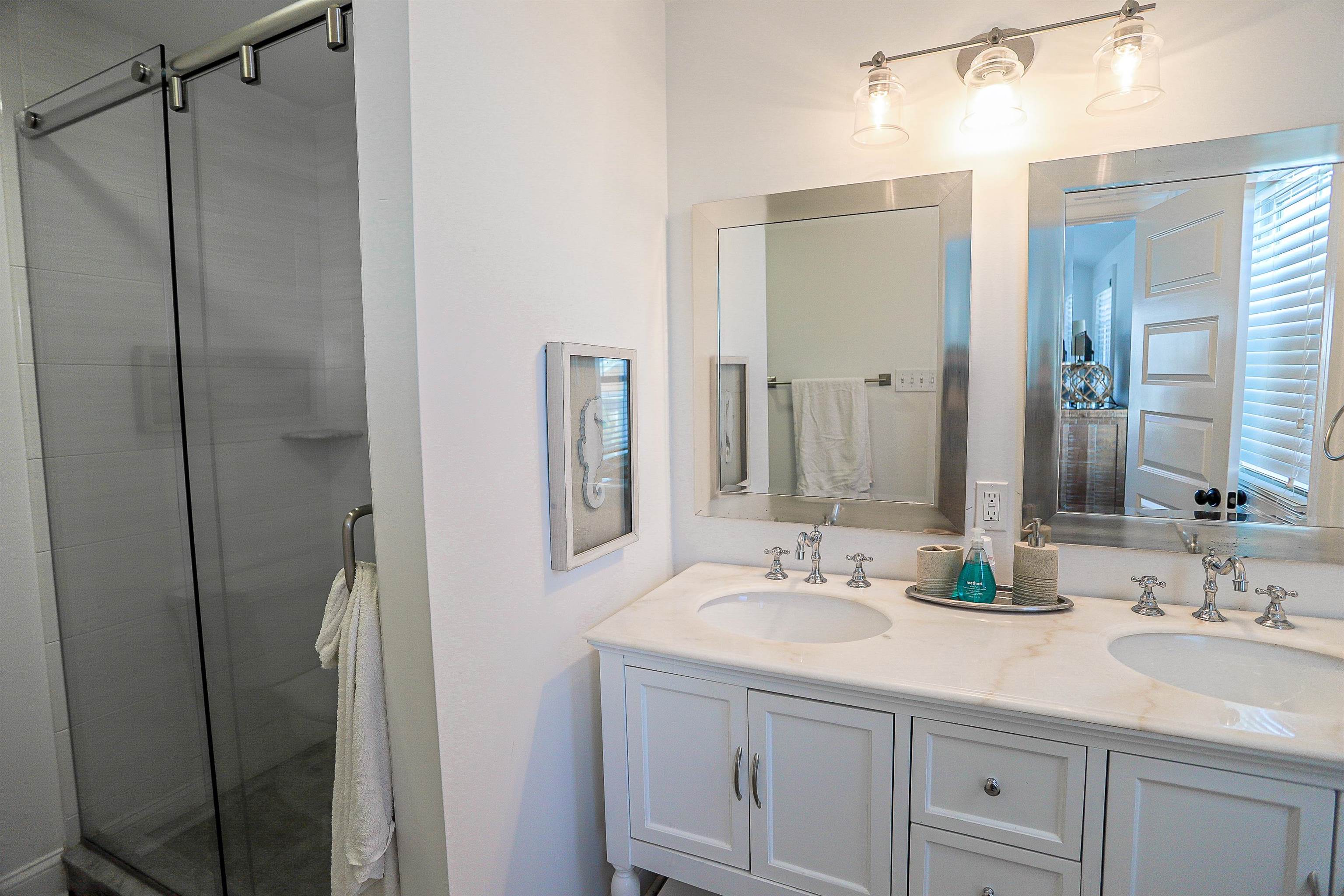 285 78th Street Avalon, NJ 08202 - Photo 34 of 48 a bathroom with a double vanity sink and mirror