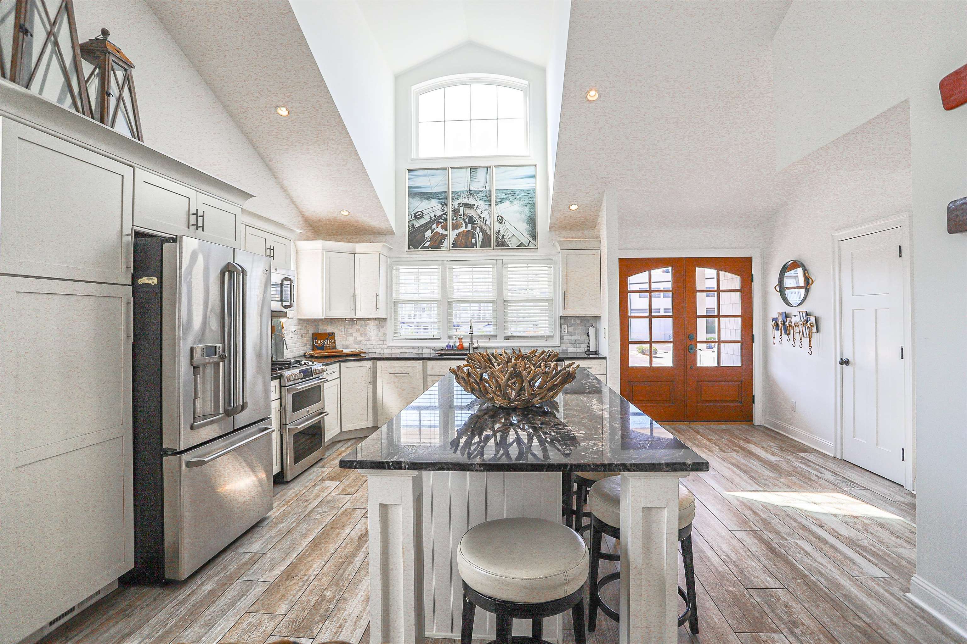 285 78th Street Avalon, NJ 08202 - Photo 8 of 48 a kitchen with stainless steel appliances a dining table chairs and window
