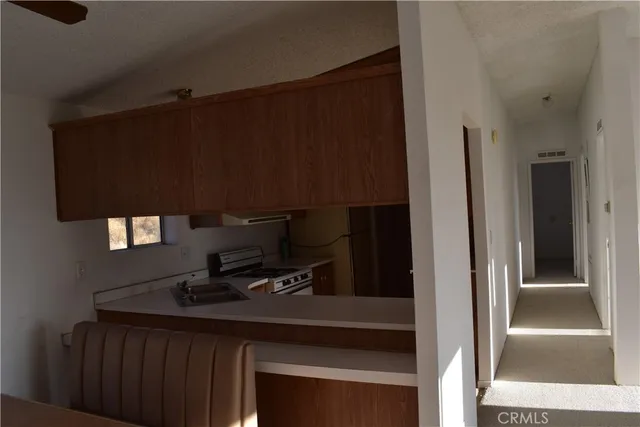 a kitchen with a refrigerator and a stove top