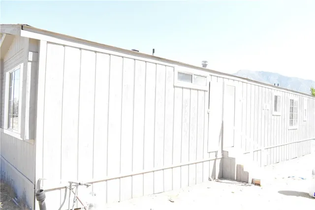 a view of a dry yard with wooden fence